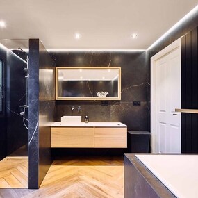 Modernes Badezimmer mit dunklen Fliesen, begehbarer Dusche, Holzwaschtisch und Badewanne.